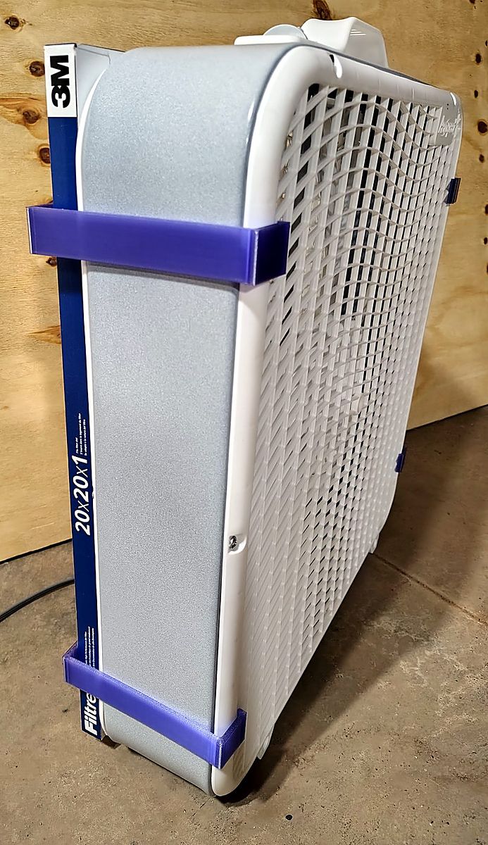 The fan from the side: one clip spans from the fan's back rim across to the filter's cardboard border